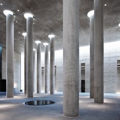 an empty room with columns and lights on the ceiling