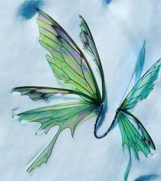 an artistic painting of a green butterfly flying through the air with wings spread wide open