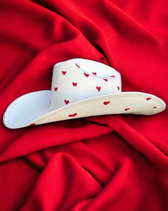 Darling features the most precious little red hearts adorning the crown and under the brim of a hard white canvas cowboy hat Proudly American Made. Our hats are manufactured in Mexico and details added by hand in Los Angeles, CA using the highest quality materials. SIZING S/M 19in-22.75in | 48cm-57.5cm L/XL 19.5in-23.25in | 49.5cm-59cm **Please allow up to 2 weeks for production and shipping.* If you need your order rushed, please send us an email. We can almost always accommodate rushed orders White Country Top Hat With Curved Brim, White Brimmed Country Top Hat, White Brimmed Country Style Top Hat, White Flat Brim Top Hat For Rodeo, White Country Style Top Hat With Curved Brim, Country Style White Brimmed Top Hat, White Brimmed Top Hat For Rodeo, White Country Style Top Hat For Western-themed Events, White Country Style Top Hat For Country Events