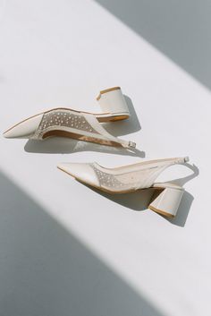 two pairs of shoes sitting on top of a white surface