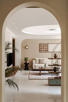 an archway leading to a living room with white furniture