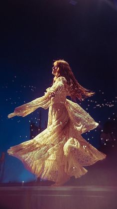 a woman in a white dress is dancing on stage