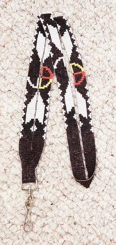 the lanyard is decorated with black, white and red designs on it's sides