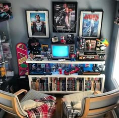 there are two chairs in front of the bookshelf with many movies on it