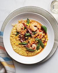 a white plate topped with shrimp and grits