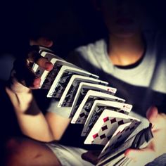 a person holding playing cards in their hands