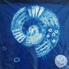 a blue and white tie - dye artwork is shown on a piece of cloth that has been cut into smaller circles