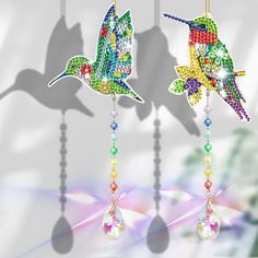 two colorful hummingbirds hanging from strings with crystal beads and dangling bead necklaces