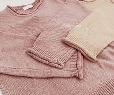 three sweaters laying on top of each other