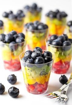 fruit salad in cups with spoons on the side