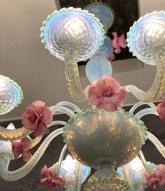 a glass chandelier with pink flowers hanging from it