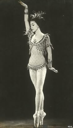 an old photo of a woman in a costume on the dance floor with her arms outstretched