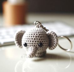 a small crocheted elephant keychain sitting on top of a desk