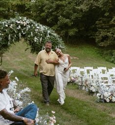 a man and woman are walking down the aisle