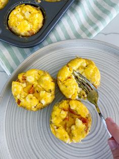 a plate with three muffins on it and a fork sticking out of one