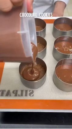 someone is pouring chocolate into small pans