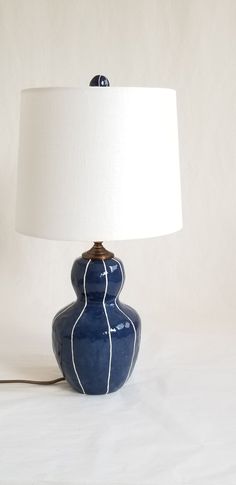 a blue lamp with a white shade on it