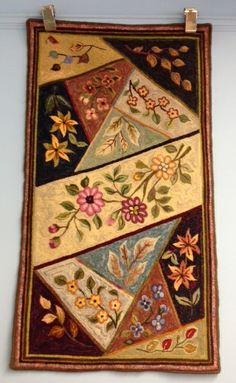 a wall hanging with flowers and leaves on it