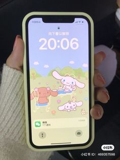 a person holding an iphone in their hand with the screen showing cartoon characters on it