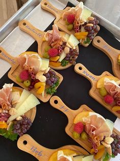 several wooden trays filled with different types of cheese and fruit on top of each other