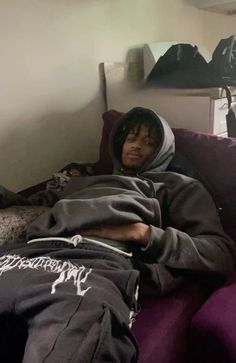 a man laying on top of a purple couch