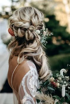 the back of a woman's head, with flowers in her hair and braid