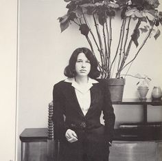 an old photo of a woman standing in front of a potted plant