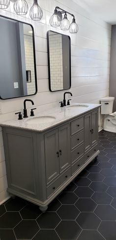 a bathroom with two sinks and three mirrors