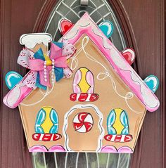 a gingerbread house shaped door hanger on a front door