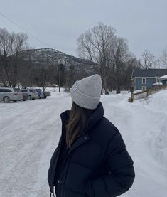 a woman standing in the middle of a snow covered road