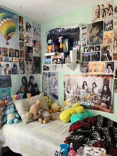 a bedroom with many pictures on the wall and stuffed animals sitting on the bedspread