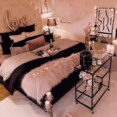 a bedroom decorated in black and white with lights on the headboard, rugs and pillows