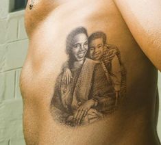 a man with a tattoo on his chest holding a woman's arm and smiling