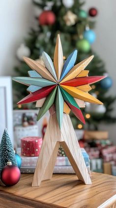 a wooden star decoration sitting on top of a table next to a christmas tree