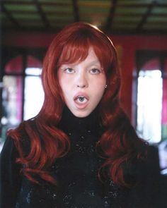 a woman with red hair making a funny face