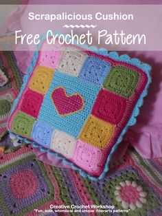 a crocheted square with hearts on it sitting next to a pillow and blanket