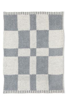 a gray and white checkered rug with fringes on the edges, in two different colors