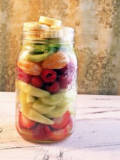 a mason jar filled with sliced fruit on top of a table