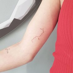 a woman's arm with a small tattoo on the left side of her arm