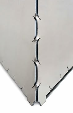 an image of a metal sheet with holes and rivets on the bottom half