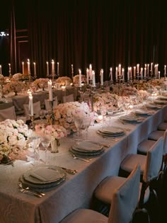 a long table is set up with white flowers and candles for an elegant dinner party