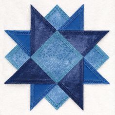 a blue and white quilted star on top of a piece of cloth in the shape of a square