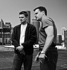 three men standing on top of a roof talking to each other