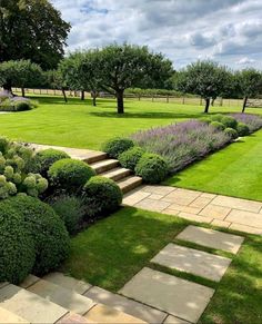 a garden with stone steps and green grass