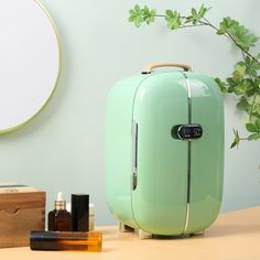 a green suitcase sitting on top of a table next to a mirror and other items