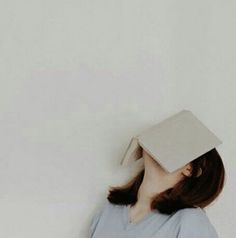 a woman wearing a graduation cap with her head in the shape of a book on top of her head