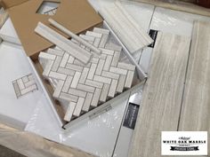 some white marble tiles are laying on top of each other in a box and ready to be put together