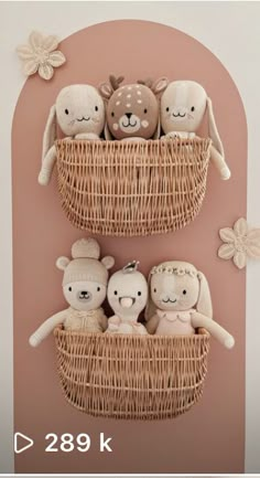 three stuffed animals are sitting in a basket on the wall, and one is wearing a knitted hat