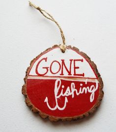 a wooden ornament with the words gone fishing on it hanging from a string