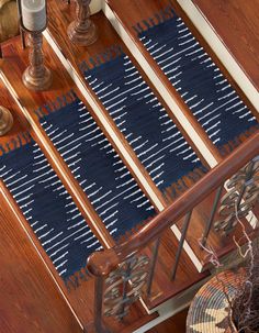 a wooden table topped with blue and white rugs on top of a hard wood floor